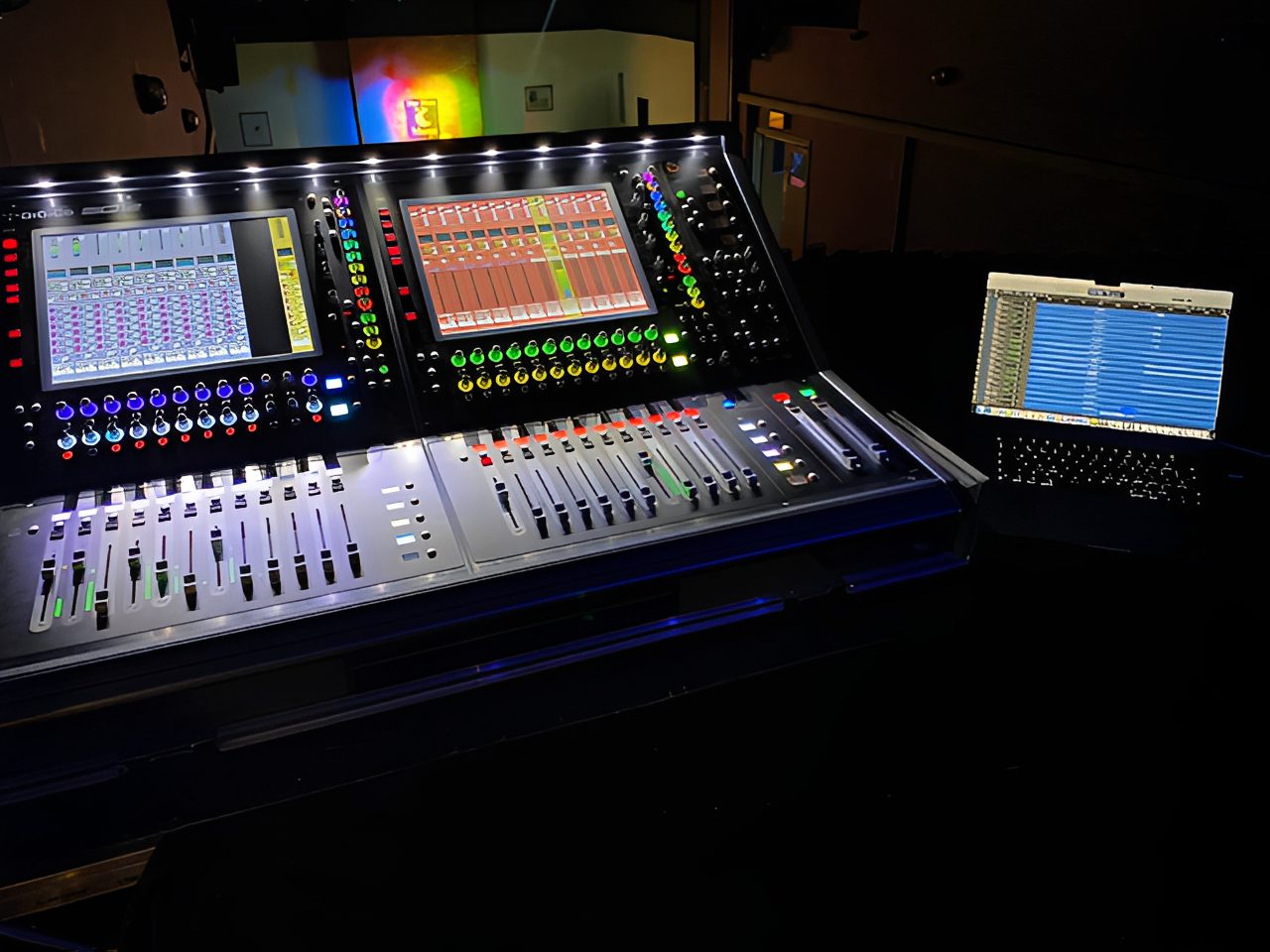 Audio mixing console with illuminated screens.