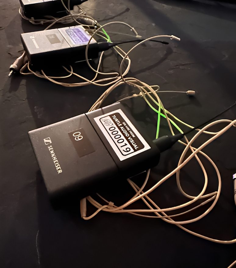 Wireless microphone packs with tangled cables.